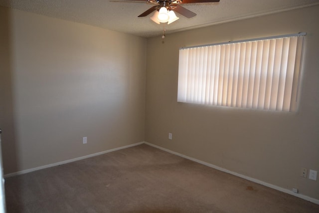 carpeted spare room featuring ceiling fan and a textured ceiling