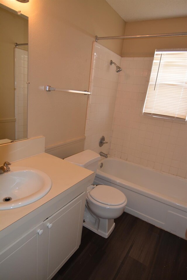 full bathroom with hardwood / wood-style flooring, vanity, toilet, and tiled shower / bath combo