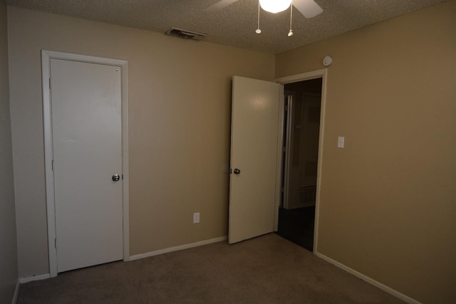 unfurnished bedroom with a textured ceiling, ceiling fan, and carpet