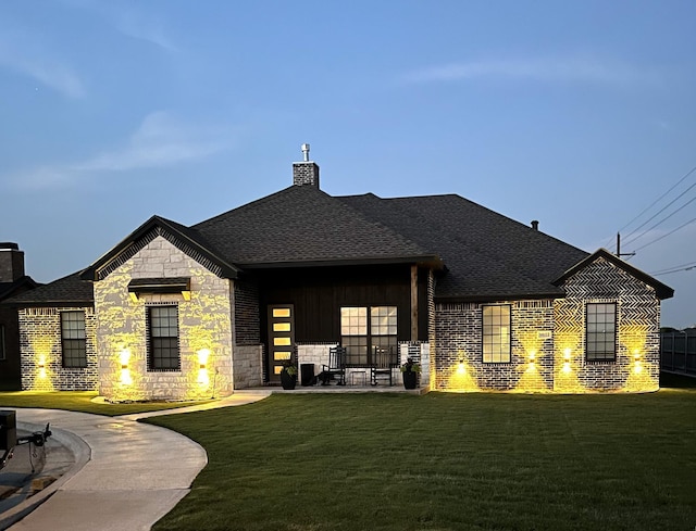 back house at dusk with a lawn