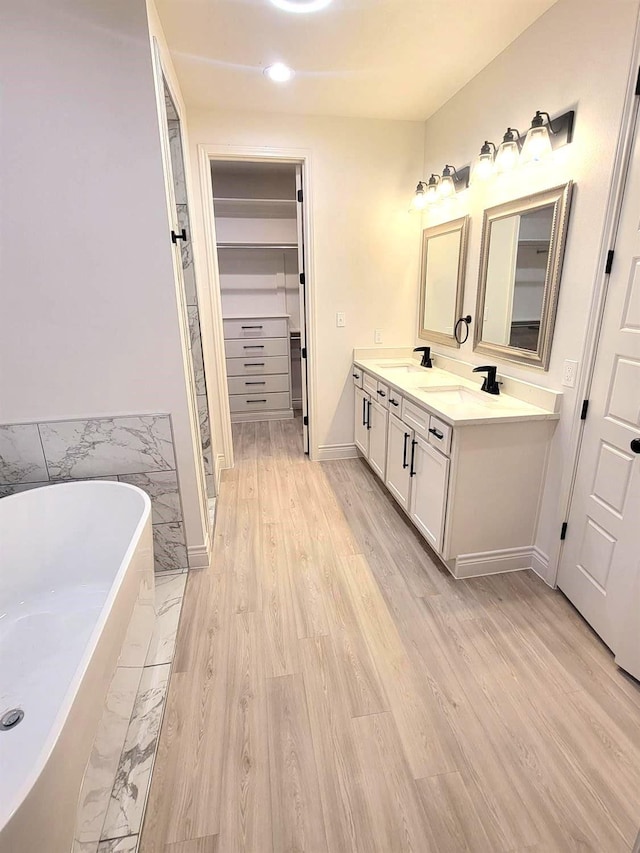 bathroom featuring vanity, wood-type flooring, and a bathing tub