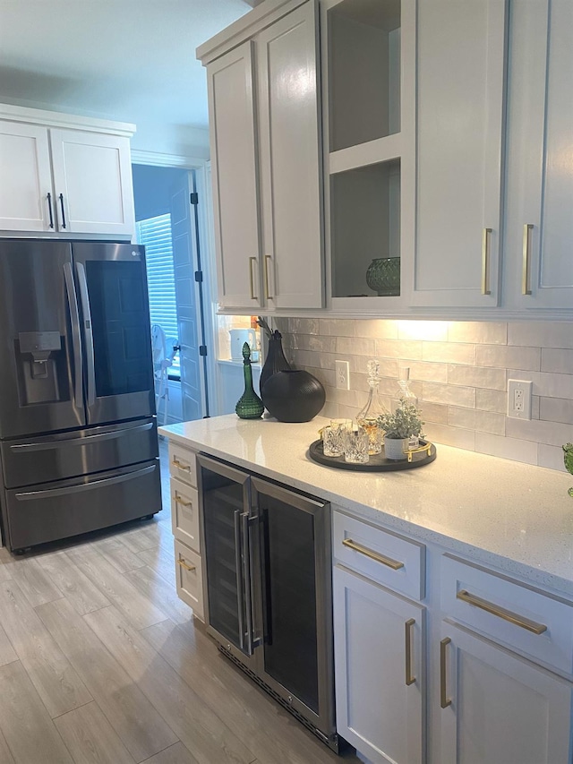 kitchen with wine cooler, stainless steel fridge with ice dispenser, decorative backsplash, and white cabinets