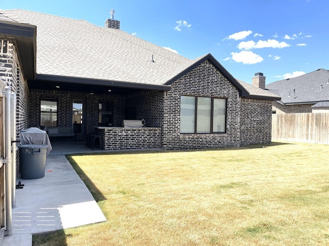 rear view of property with a patio and a lawn