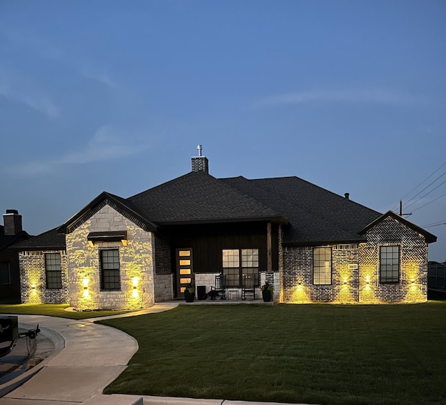 back house at dusk featuring a yard