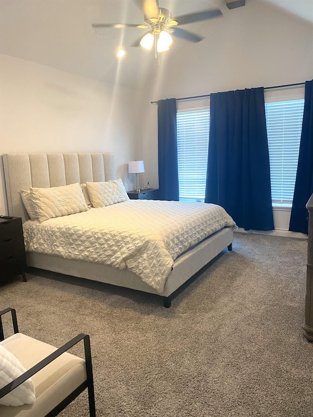 bedroom featuring multiple windows, vaulted ceiling, ceiling fan, and carpet flooring