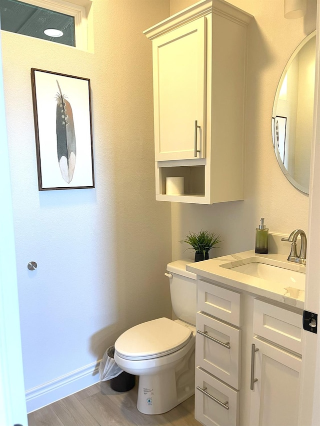 bathroom with vanity, wood-type flooring, and toilet