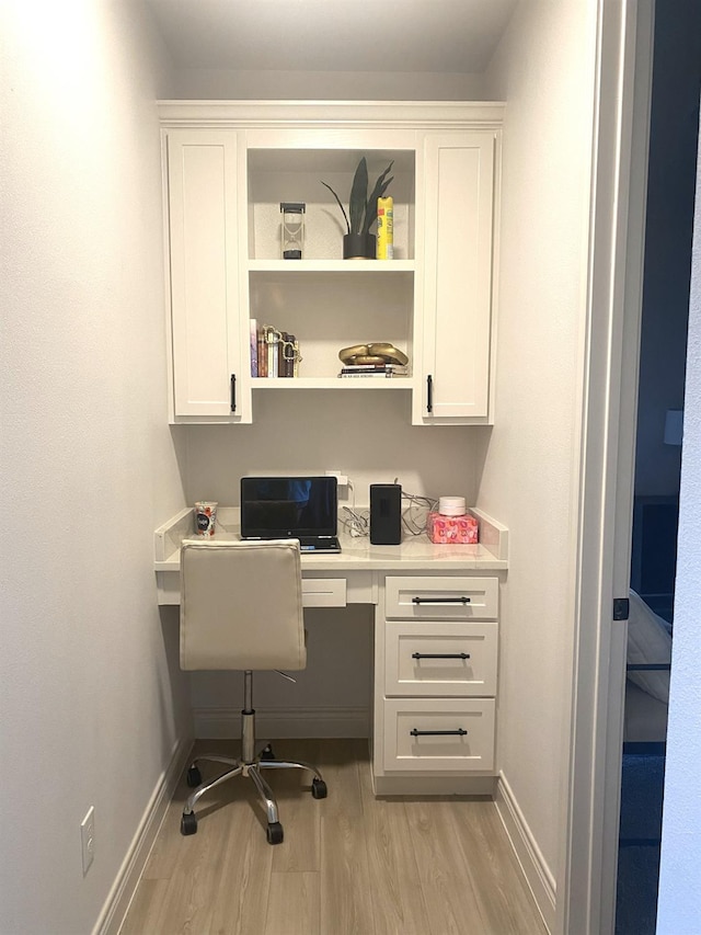 office with built in desk and light hardwood / wood-style flooring