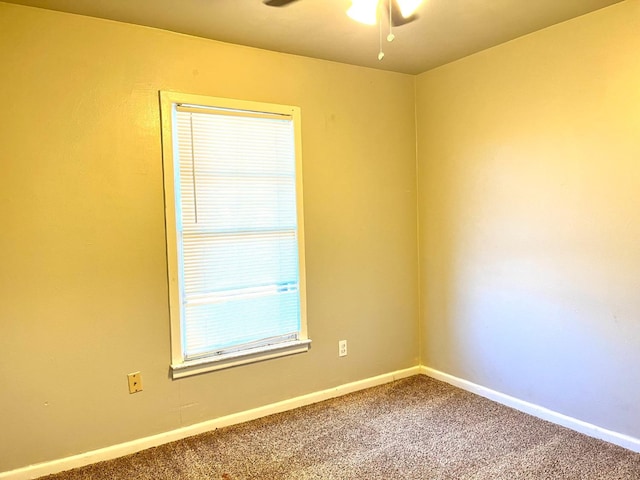 spare room with ceiling fan and carpet