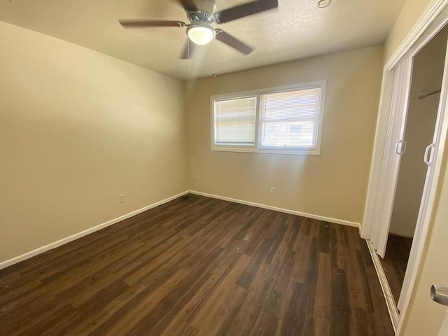 unfurnished bedroom with dark hardwood / wood-style flooring, a textured ceiling, and ceiling fan