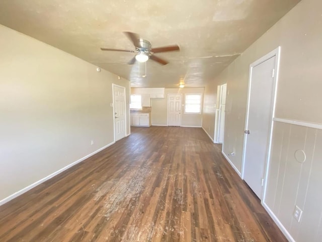 unfurnished living room featuring ceiling fan and dark hardwood / wood-style floors