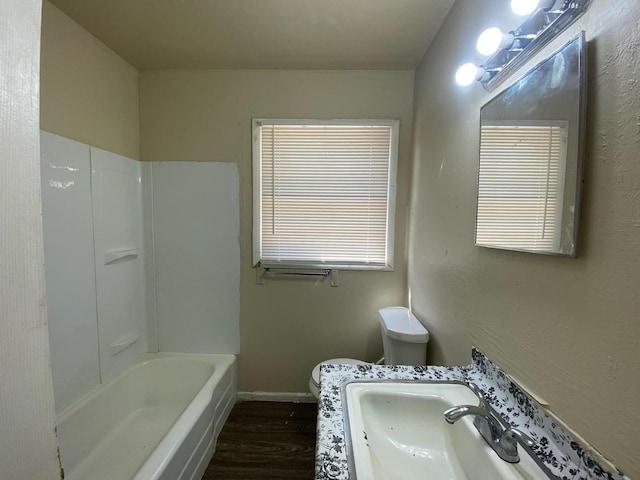 bathroom with hardwood / wood-style flooring, toilet, and sink