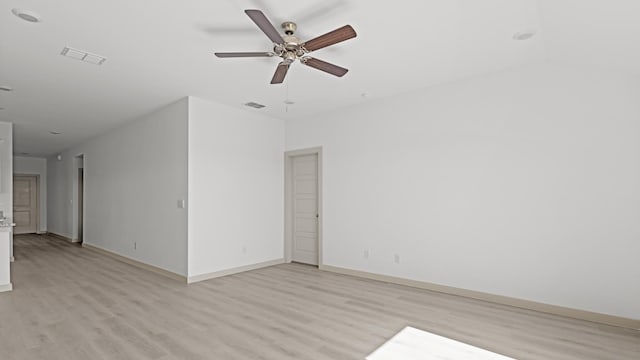 empty room with light wood-style flooring, a ceiling fan, and baseboards