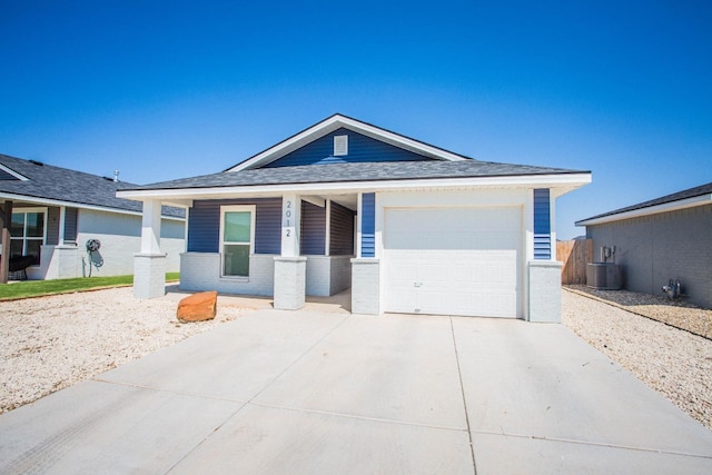 ranch-style home featuring a garage and cooling unit