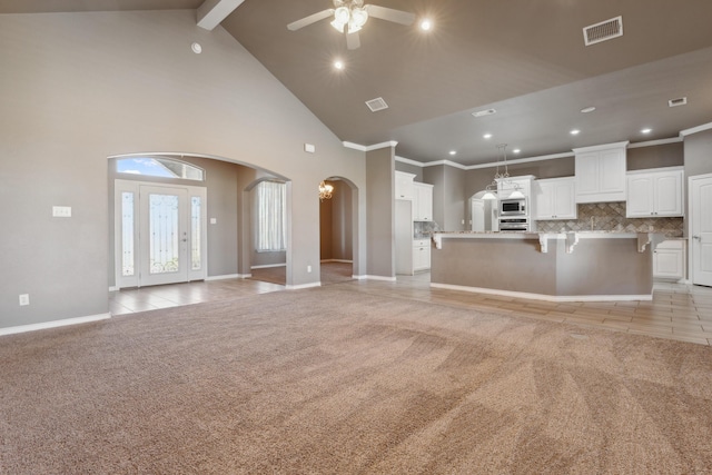 2007 County Rd 7560, Lubbock, TX 79423 - unfurnished living room with arched walkways, light carpet, ceiling fan, high vaulted ceiling, and recessed lighting