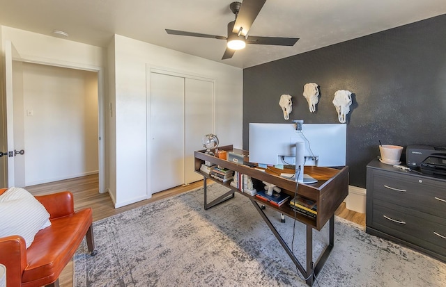 office with light hardwood / wood-style floors and ceiling fan