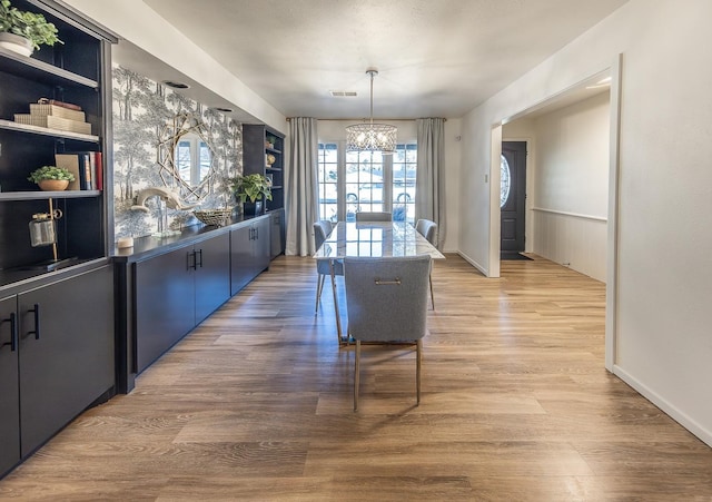 dining area with an inviting chandelier and light hardwood / wood-style floors