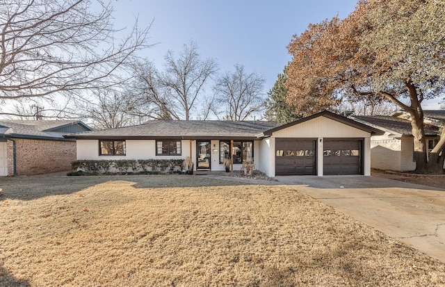 ranch-style house featuring a garage and a front lawn