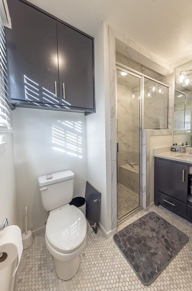 bathroom featuring an enclosed shower, vanity, tile patterned floors, and toilet