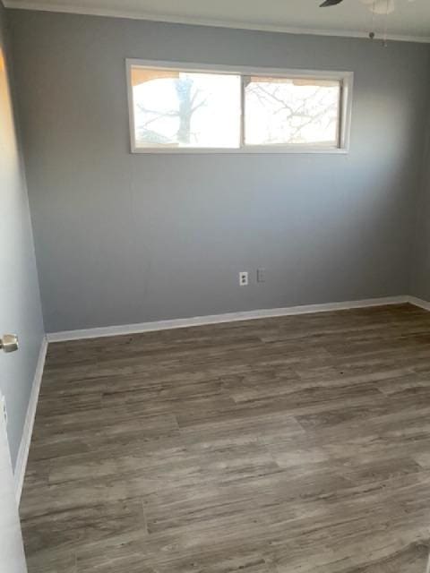 empty room with dark hardwood / wood-style flooring, crown molding, and ceiling fan