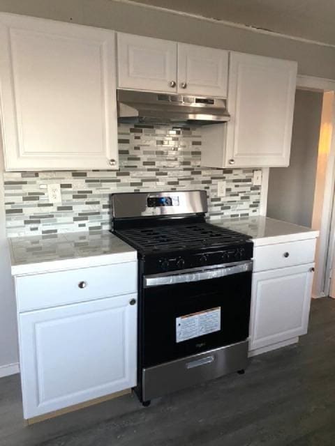 kitchen with tasteful backsplash, stainless steel range with gas cooktop, white cabinets, and dark hardwood / wood-style flooring