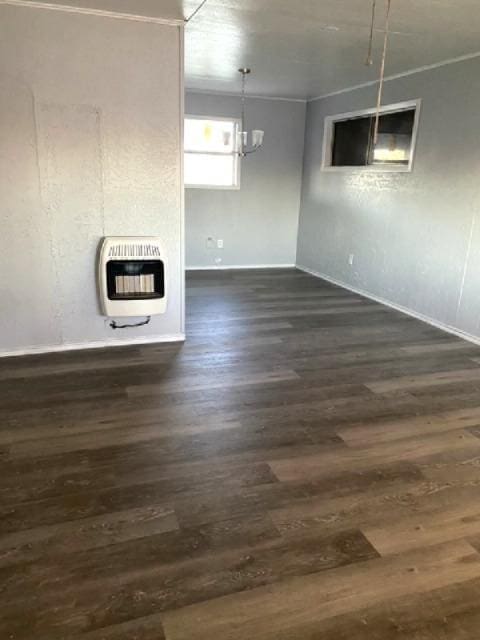 interior space featuring heating unit, dark wood-type flooring, and a chandelier