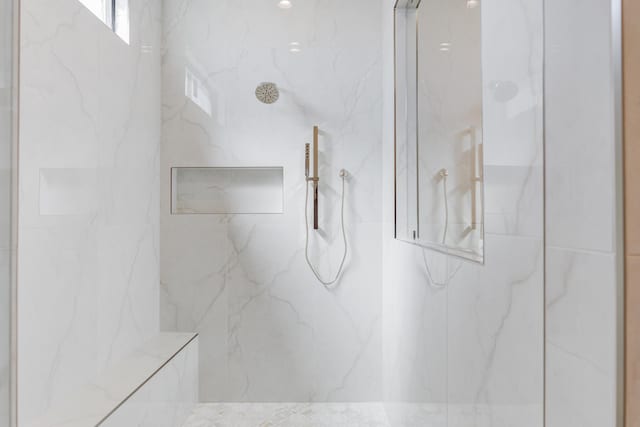 full bathroom featuring a marble finish shower