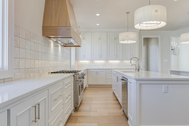 kitchen featuring custom exhaust hood, a sink, light countertops, stainless steel appliances, and backsplash