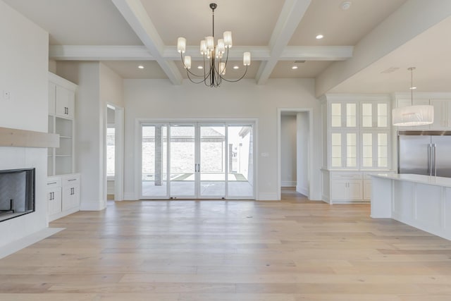 unfurnished living room featuring a chandelier, light wood-type flooring, baseboards, and beam ceiling
