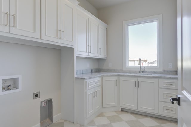 laundry area with electric dryer hookup, washer hookup, a sink, baseboards, and cabinet space