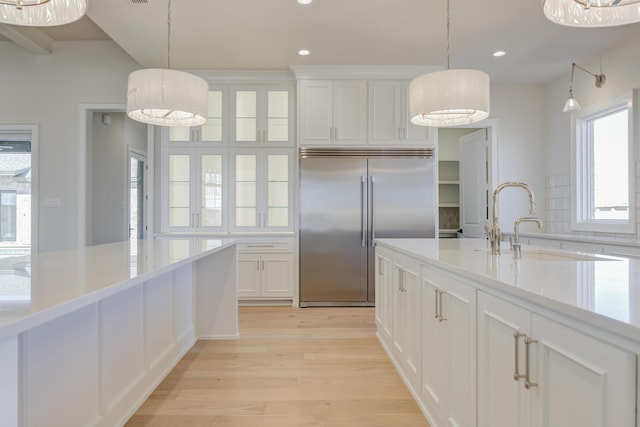 kitchen featuring light wood-type flooring, white cabinetry, recessed lighting, light countertops, and built in fridge