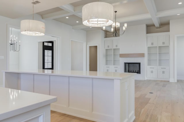 kitchen with coffered ceiling, beam ceiling, light wood-type flooring, and a notable chandelier