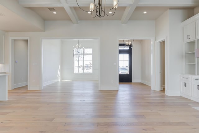 interior space with coffered ceiling, beam ceiling, an inviting chandelier, and light wood-style floors