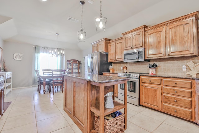 kitchen with appliances with stainless steel finishes, light tile patterned floors, dark stone countertops, and open shelves