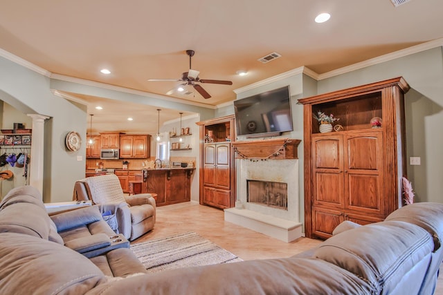 living room with decorative columns, visible vents, light wood-type flooring, a fireplace, and recessed lighting