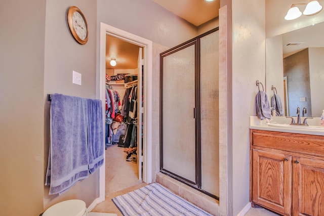 full bathroom with visible vents, a shower stall, vanity, and a spacious closet