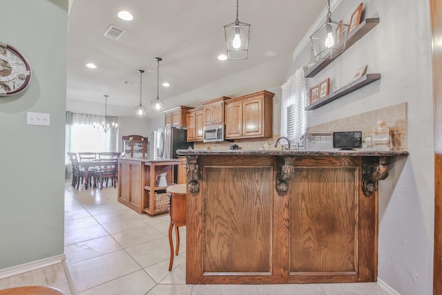 kitchen with a breakfast bar area, light tile patterned floors, stainless steel appliances, visible vents, and a sink