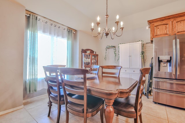 dining space with baseboards, a notable chandelier, and light tile patterned flooring