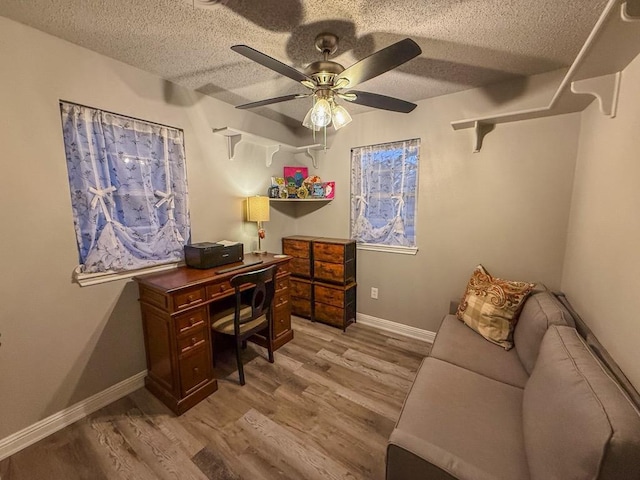 office with a textured ceiling, light hardwood / wood-style floors, and ceiling fan