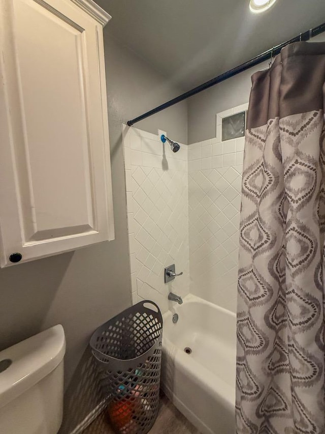 bathroom with shower / tub combo with curtain and toilet
