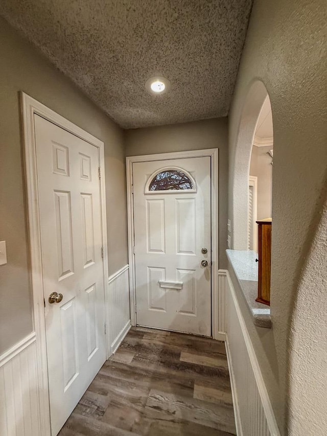 doorway to outside featuring dark wood-type flooring and a textured ceiling
