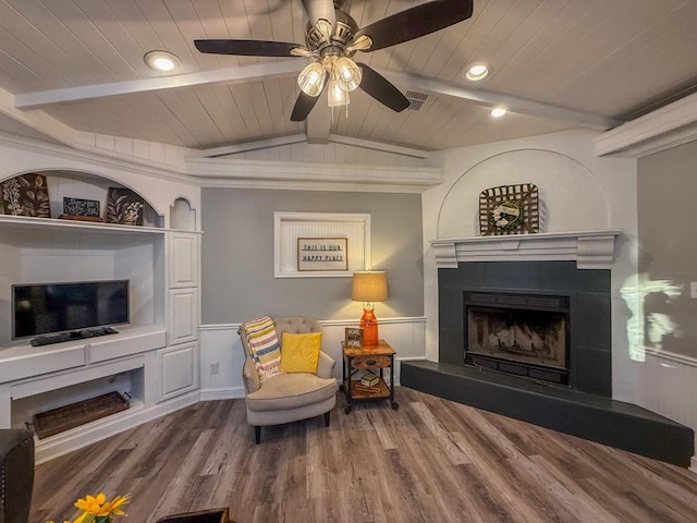 sitting room featuring hardwood / wood-style floors, wood ceiling, lofted ceiling with beams, and a tile fireplace