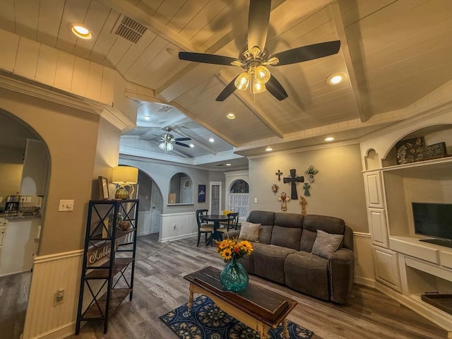 living room with dark hardwood / wood-style flooring, ceiling fan, wooden ceiling, and beamed ceiling