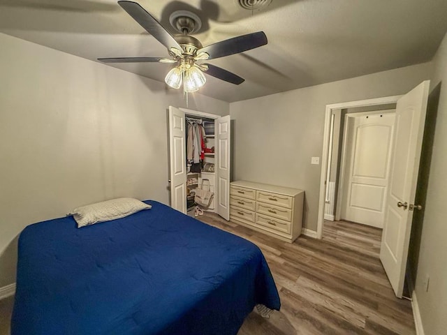 bedroom with hardwood / wood-style flooring, a closet, and ceiling fan