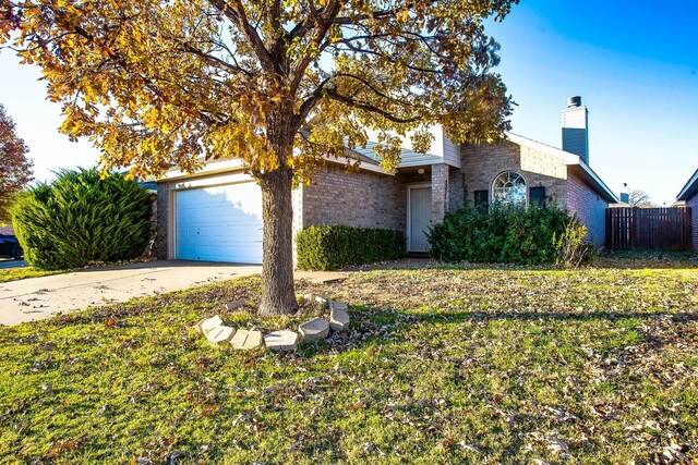 view of front of property featuring a garage and a front lawn