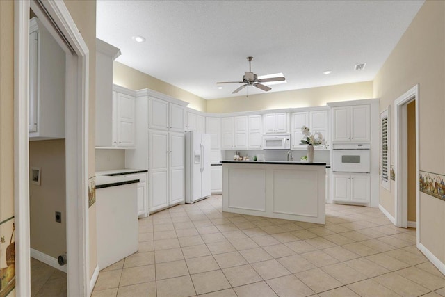 kitchen featuring light tile patterned flooring, white appliances, ceiling fan, and white cabinets