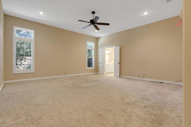 unfurnished room featuring a wealth of natural light, light colored carpet, and ceiling fan