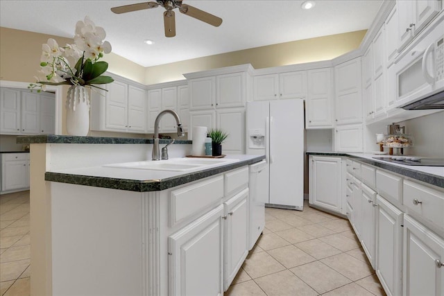 kitchen featuring white cabinetry, white appliances, sink, and an island with sink