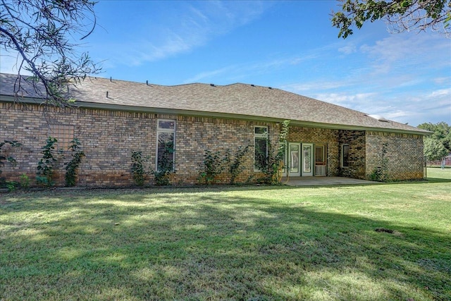 back of house with a yard and a patio