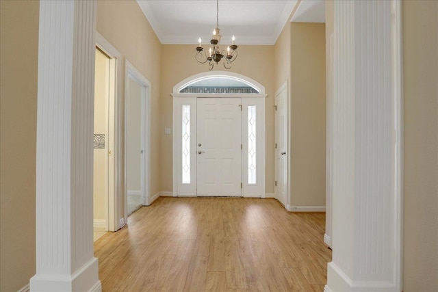 foyer featuring an inviting chandelier, light hardwood / wood-style flooring, and ornamental molding