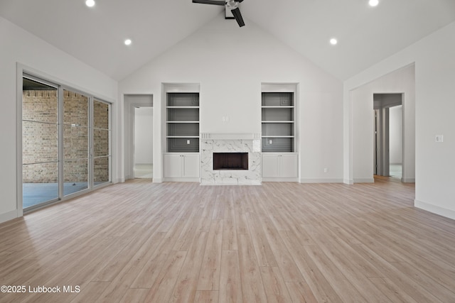 4614 138th Pl, Lubbock, TX 79424 - unfurnished living room featuring built in shelves, light wood-style flooring, ceiling fan, recessed lighting, and a high end fireplace